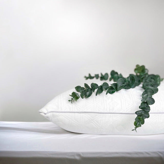 Wit OnePillow hoofdkussen op een licht bed
